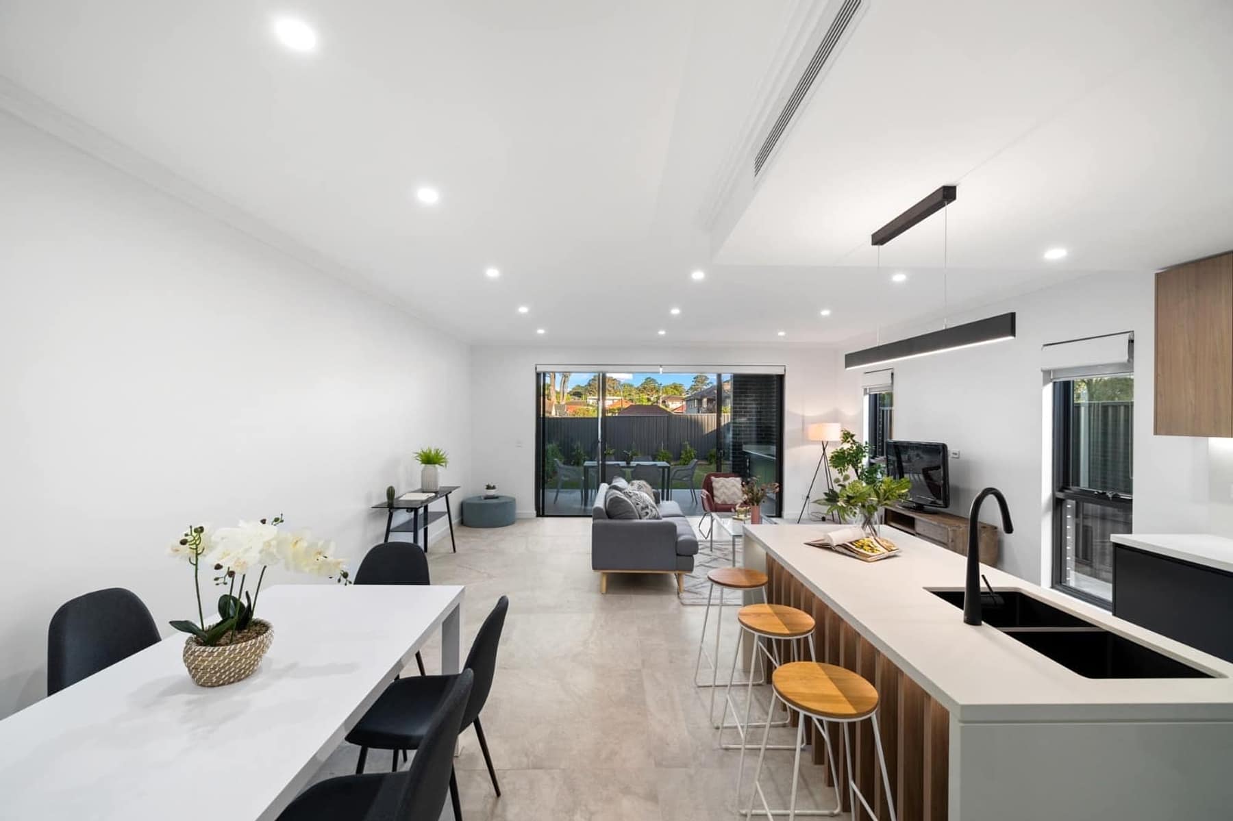 Dining and living zone looking through sliding doors to the rear alfresco